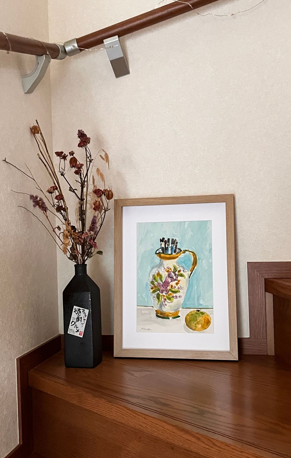 鉛筆の入った水差しと果物